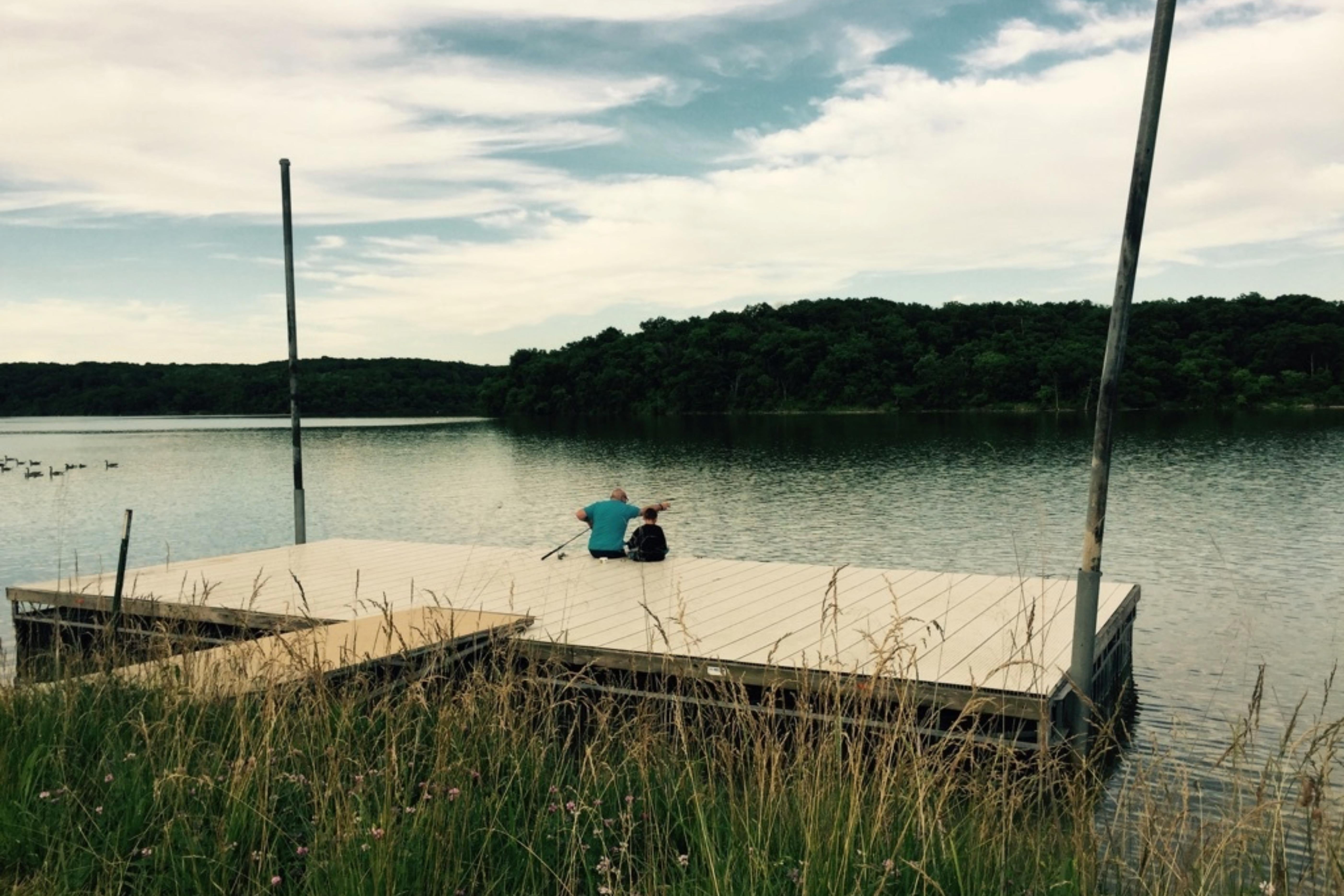 Father and son finishing on a dock