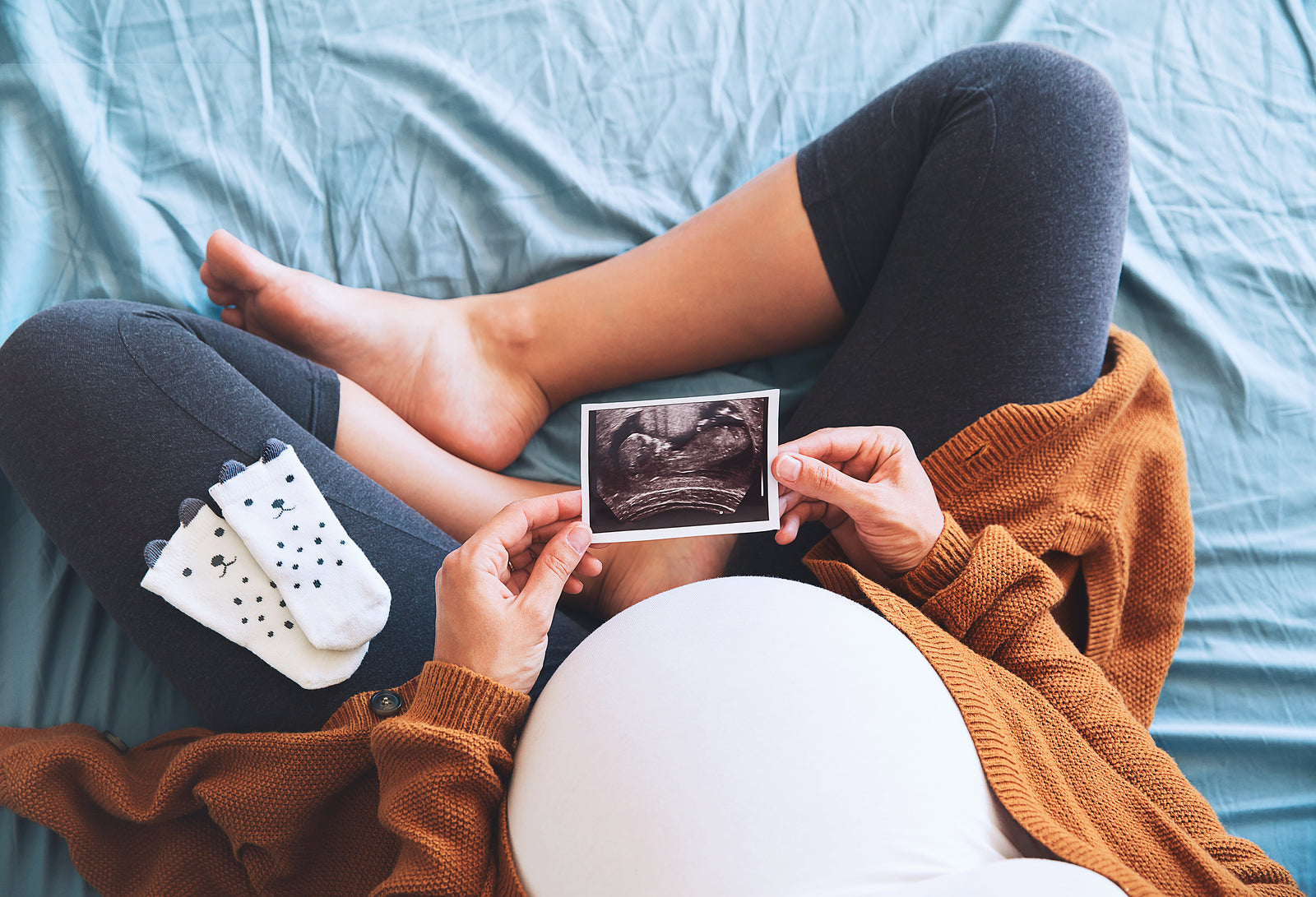 Pregnant woman holding ultrasound image