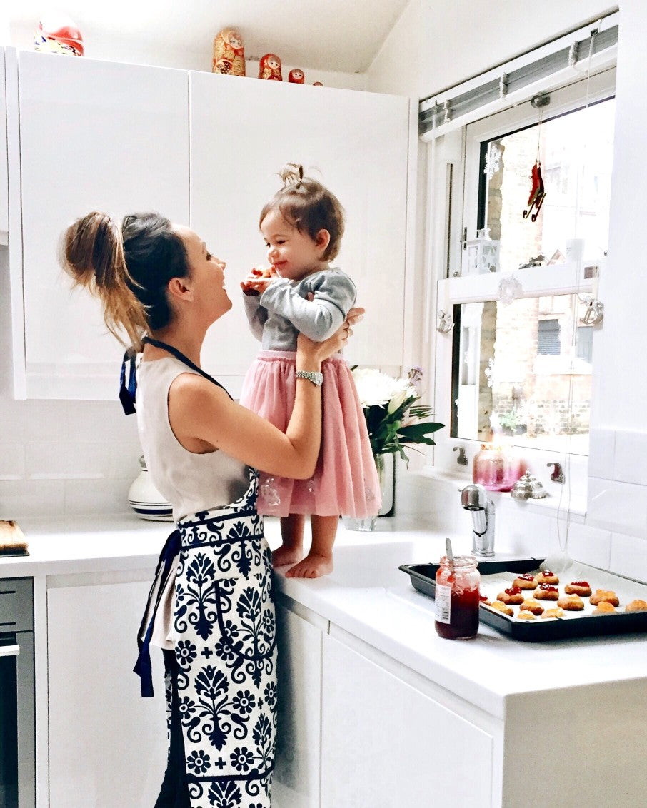 Mom smiling with daughter cooking
