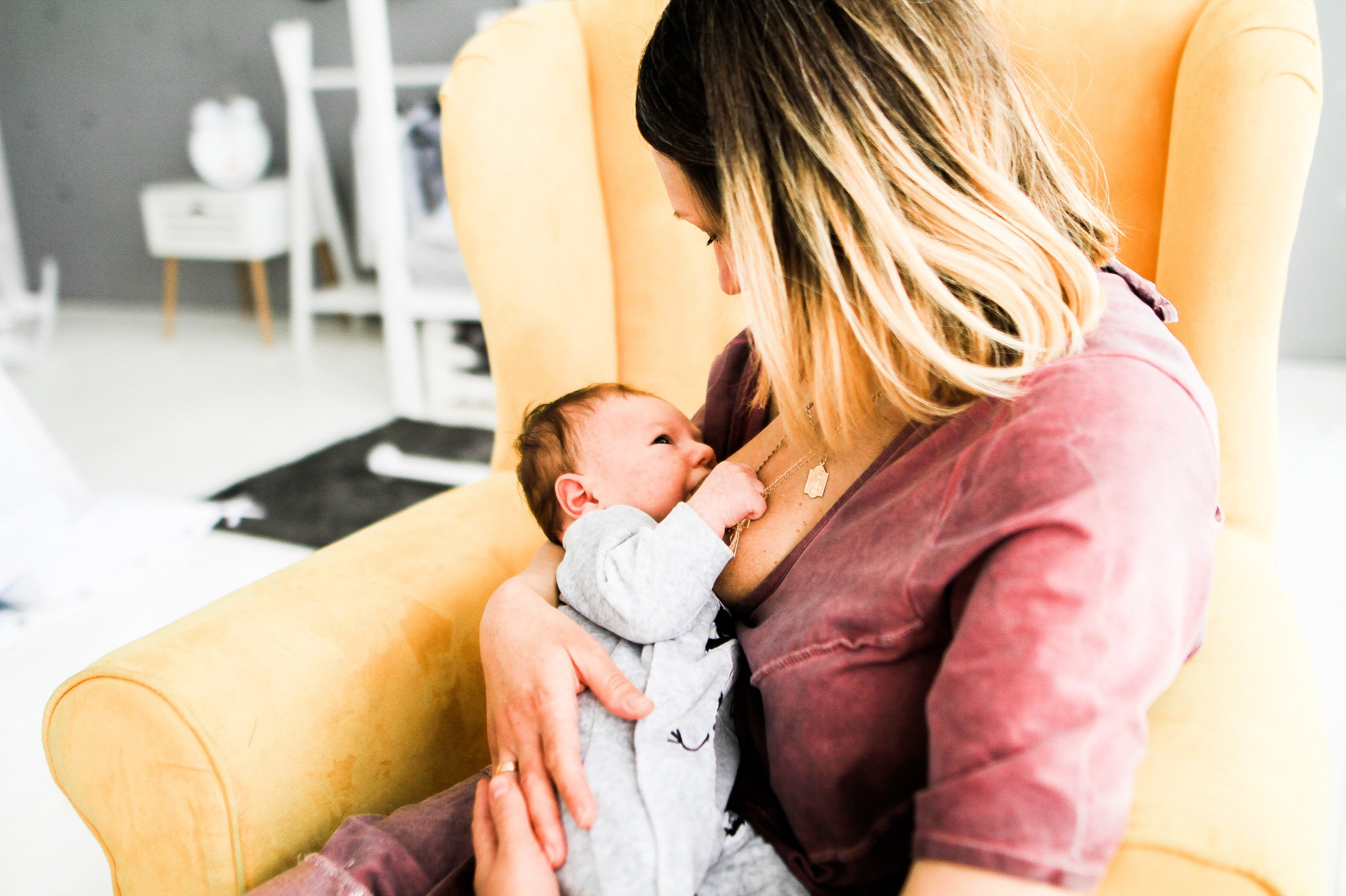 Mother looks at her baby breastfeeding